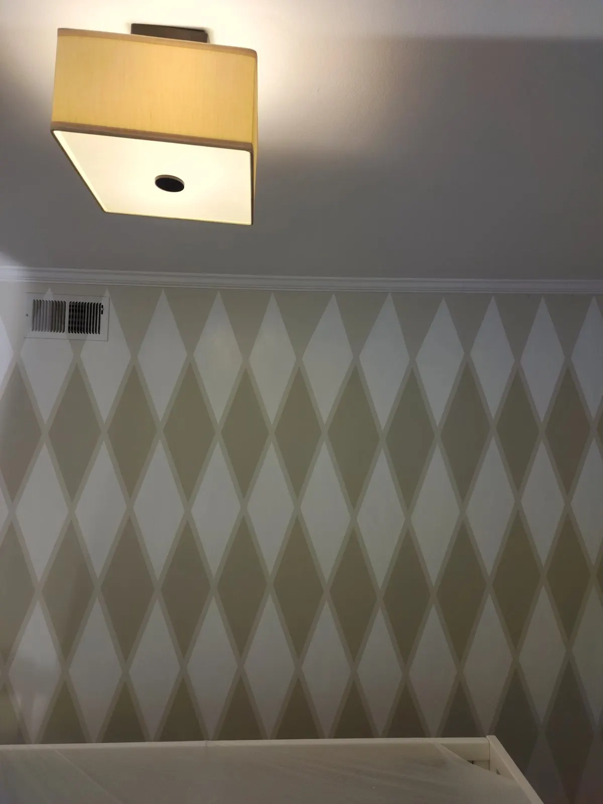 Diamond-pattern accent wall under a square ceiling light