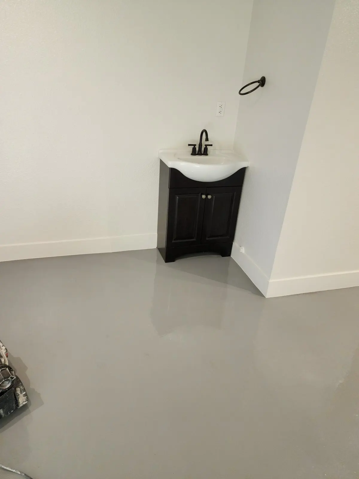 Bathroom corner with fresh white walls and a dark wood vanity