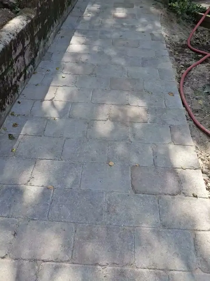 The same walkway along the stone wall, rebuilt in new gray pavers