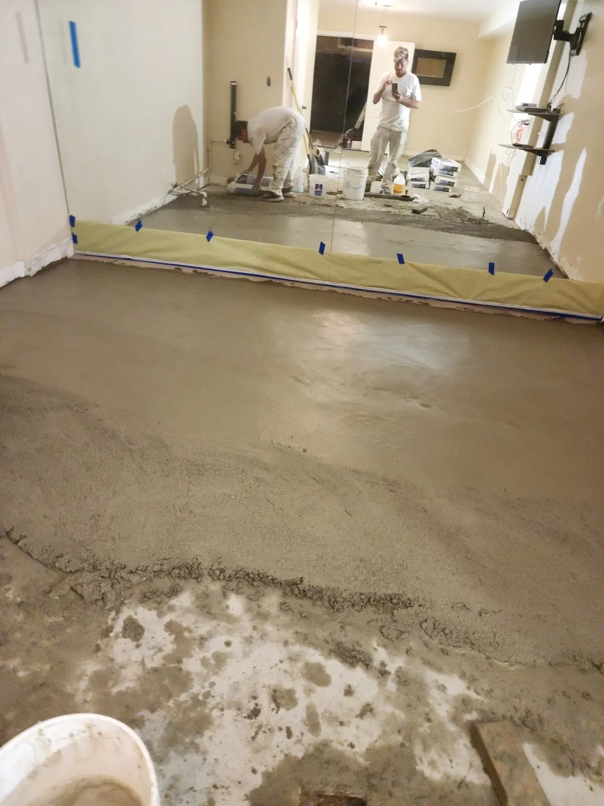 Floor leveling compound spread across a room after old flooring was removed