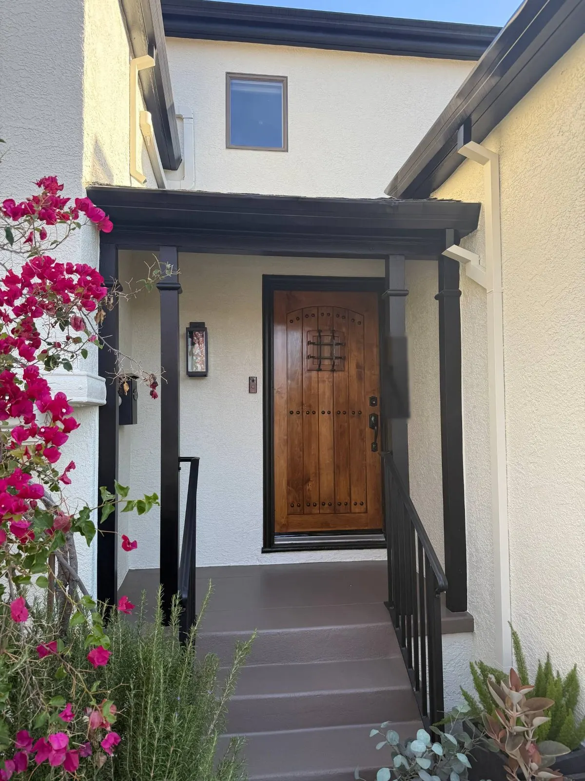 Stucco front entry painted white with black posts and trim